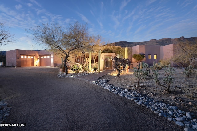 adobe home with a garage and a mountain view