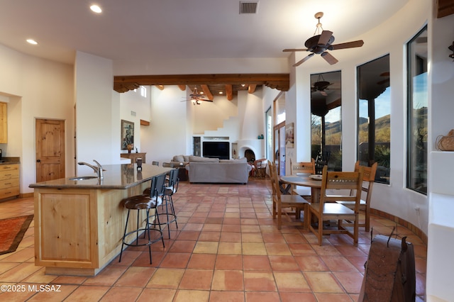 kitchen with light tile patterned flooring, a kitchen bar, light brown cabinetry, and sink