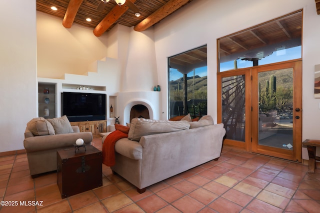 tiled living room featuring beamed ceiling, a towering ceiling, a fireplace, and wood ceiling