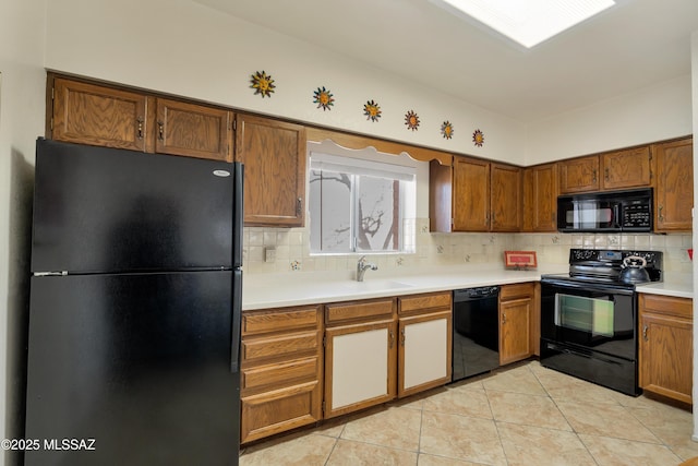 kitchen with light tile patterned floors, sink, decorative backsplash, and black appliances