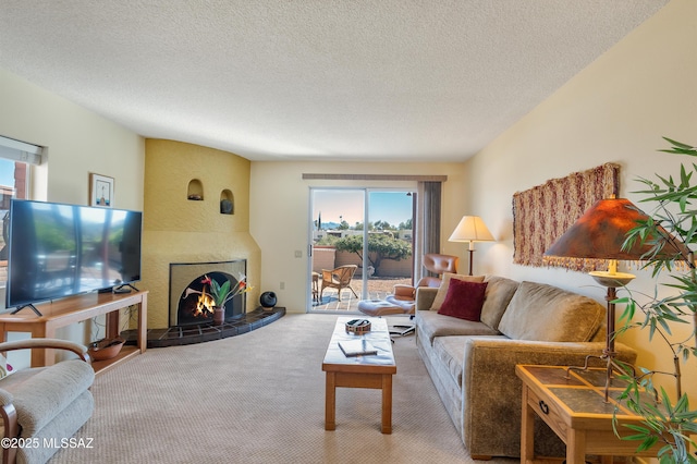 carpeted living room featuring a tile fireplace and a textured ceiling