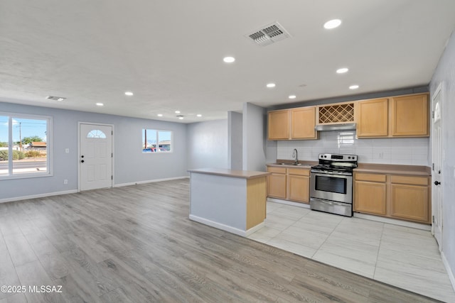 kitchen with light brown cabinetry, sink, stainless steel range with electric stovetop, light hardwood / wood-style flooring, and backsplash