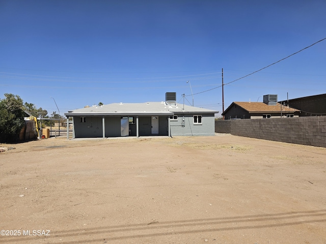 back of property featuring central AC and fence