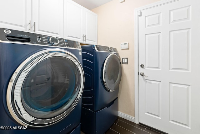 clothes washing area with cabinets and washer and dryer