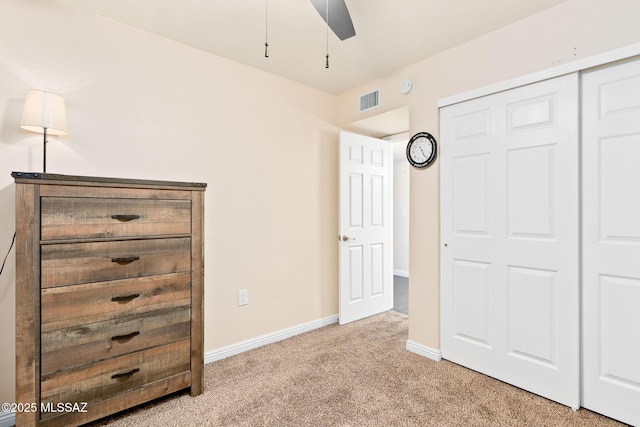 unfurnished bedroom featuring light colored carpet and a closet