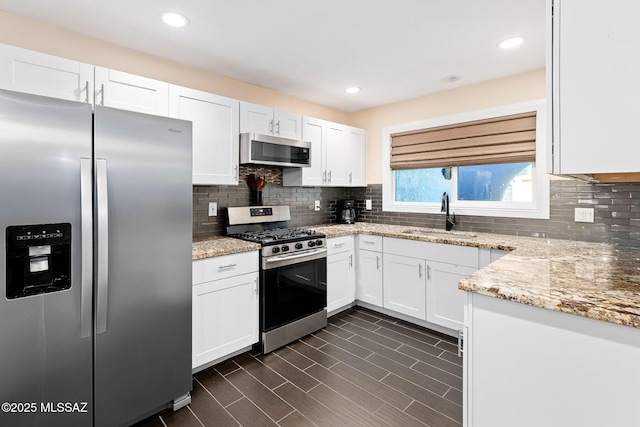 kitchen featuring appliances with stainless steel finishes, sink, and white cabinets