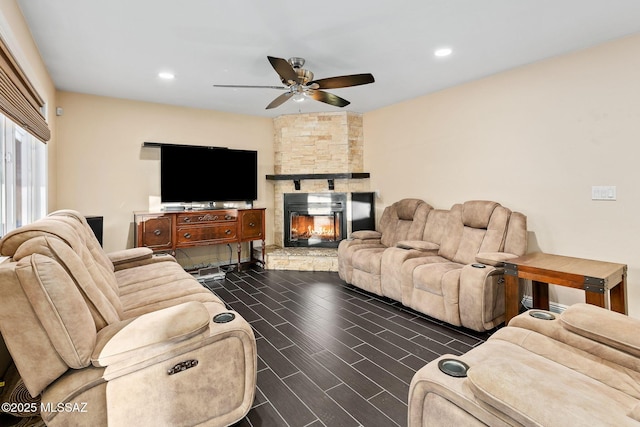 living room with ceiling fan, dark hardwood / wood-style floors, and a fireplace