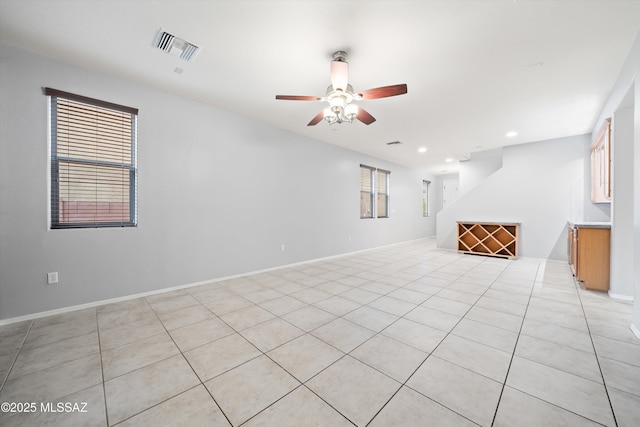 unfurnished living room featuring light tile patterned floors and ceiling fan
