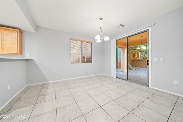 unfurnished dining area with an inviting chandelier and light tile patterned flooring
