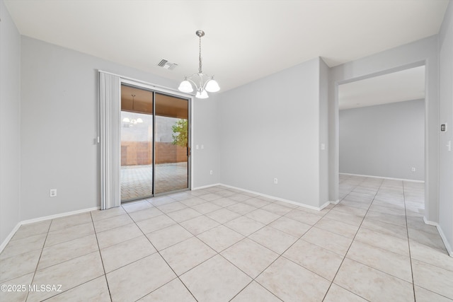 tiled empty room with an inviting chandelier