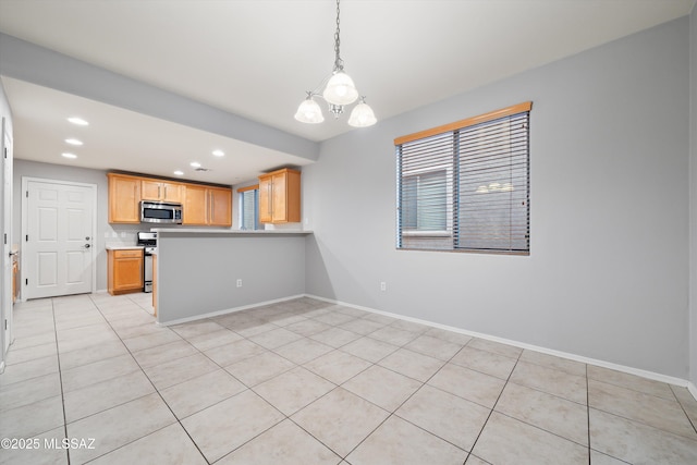 kitchen with light tile patterned flooring, hanging light fixtures, appliances with stainless steel finishes, kitchen peninsula, and a notable chandelier