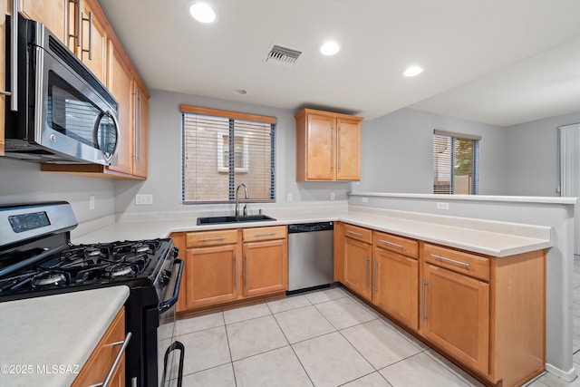 kitchen featuring stainless steel appliances, sink, light tile patterned floors, and kitchen peninsula