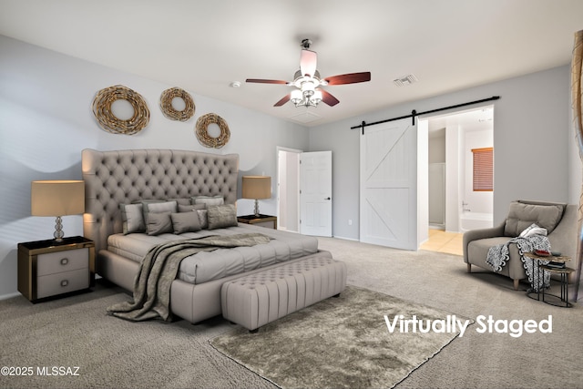 carpeted bedroom with ceiling fan, ensuite bathroom, and a barn door
