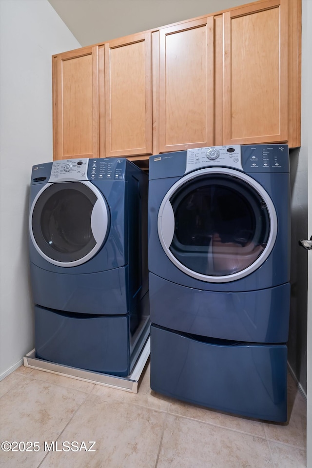 laundry room with washing machine and dryer and cabinets