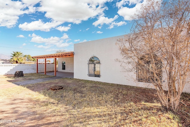 view of property exterior with a patio and a yard