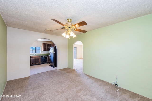 carpeted spare room featuring ceiling fan, sink, and a textured ceiling