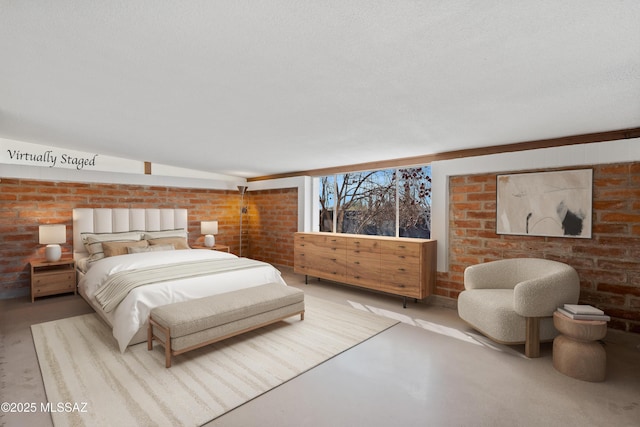 bedroom with brick wall, concrete floors, and a textured ceiling