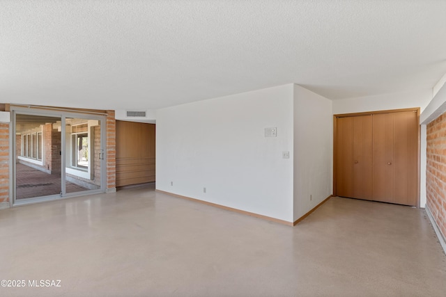 unfurnished room with a textured ceiling