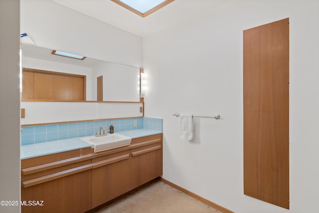 bathroom with vanity, a skylight, and backsplash