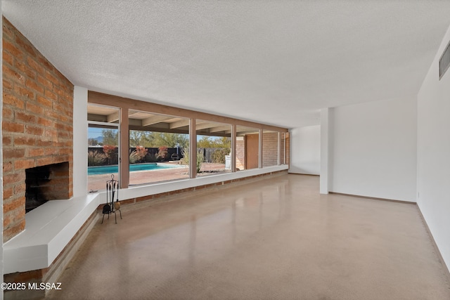 unfurnished living room featuring a brick fireplace and a textured ceiling