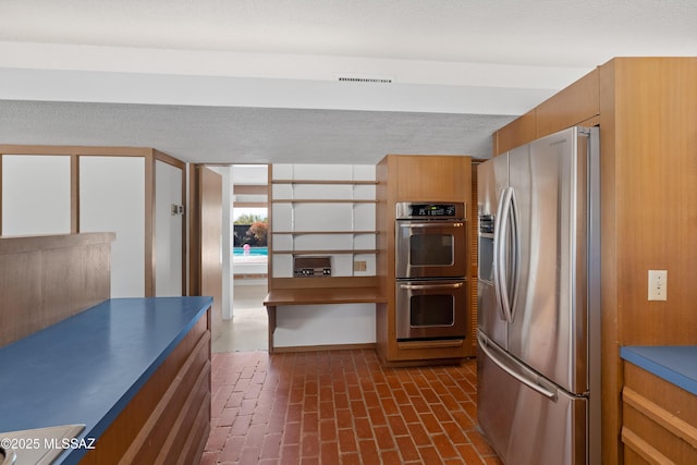 kitchen featuring stainless steel appliances and a textured ceiling