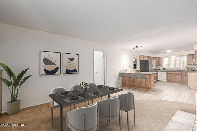 dining area with light tile patterned flooring, light colored carpet, and a textured wall