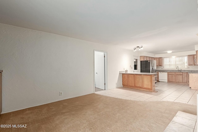 kitchen with light carpet, a peninsula, stainless steel refrigerator with ice dispenser, white dishwasher, and light tile patterned flooring