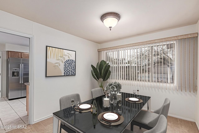 dining space with light colored carpet and baseboards