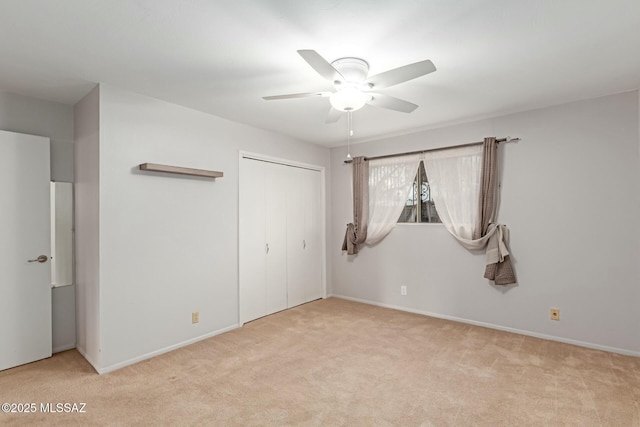 unfurnished bedroom with ceiling fan, light colored carpet, and a closet