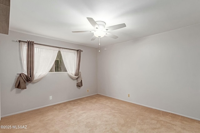 unfurnished room featuring baseboards, light carpet, and ceiling fan