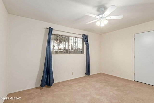 empty room featuring light colored carpet and ceiling fan