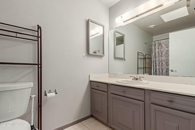 bathroom with tile patterned flooring, toilet, vanity, and baseboards