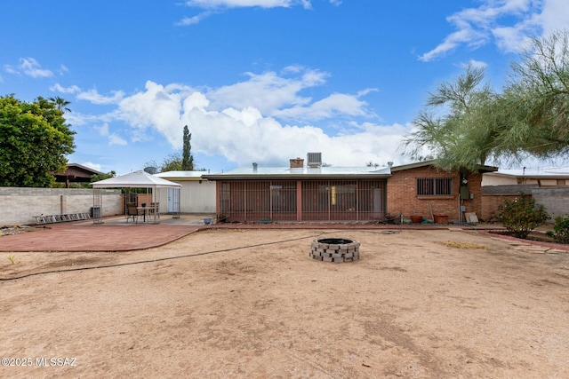 rear view of property featuring a gazebo, an outdoor fire pit, and a patio