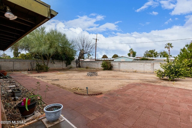 view of yard featuring a fenced backyard, an outdoor fire pit, and a patio
