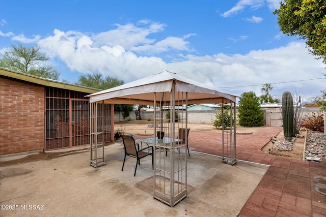 view of patio / terrace with a gazebo, outdoor dining space, and fence