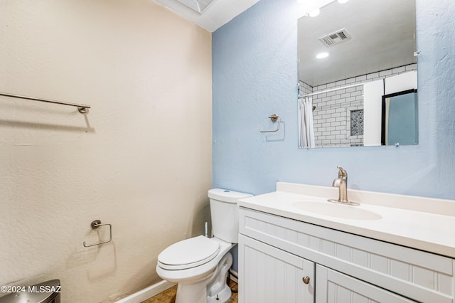 bathroom with walk in shower, vanity, and toilet