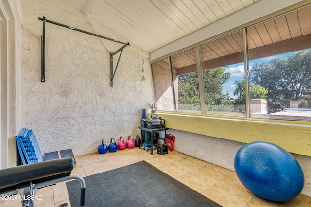 workout area with tile patterned floors and vaulted ceiling