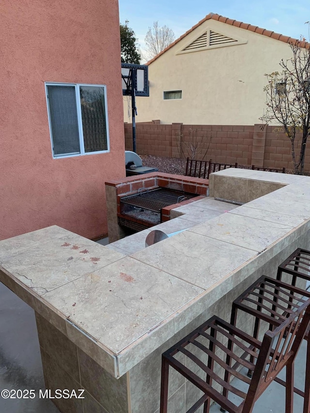 view of patio featuring exterior bar and an outdoor kitchen