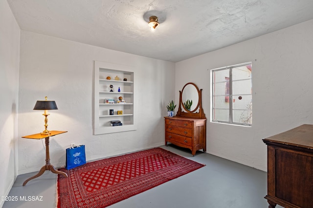 bedroom featuring concrete flooring and a textured ceiling