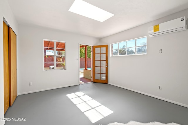 spare room with a skylight, a wall unit AC, and french doors