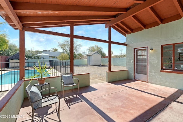 view of patio with a fenced in pool and a shed