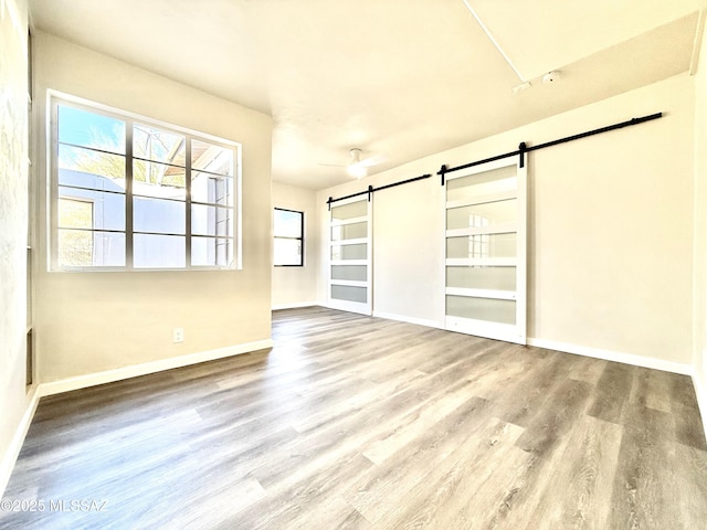 empty room with hardwood / wood-style flooring and a barn door