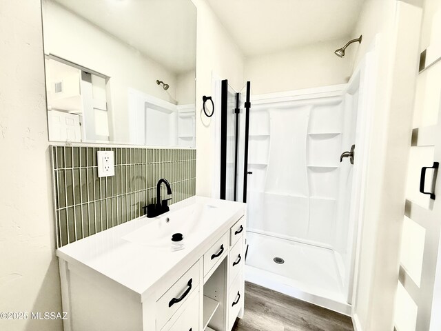 bathroom with hardwood / wood-style flooring, vanity, an enclosed shower, and toilet