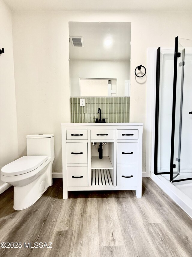 bathroom featuring hardwood / wood-style flooring, vanity, and walk in shower