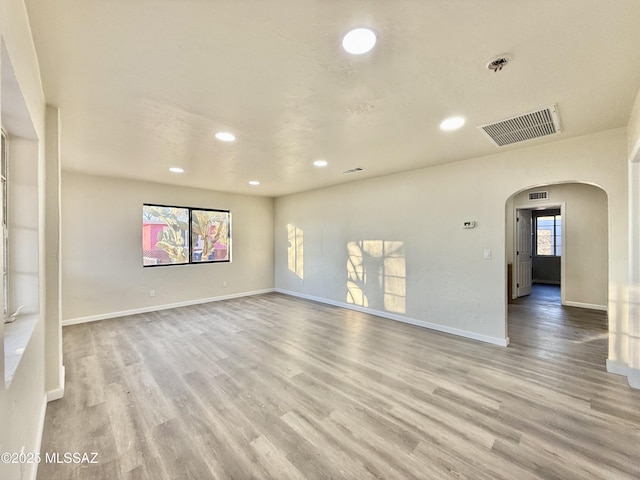 empty room featuring a healthy amount of sunlight and light hardwood / wood-style flooring