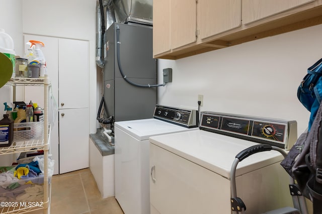 laundry area with cabinets, separate washer and dryer, and light tile patterned floors