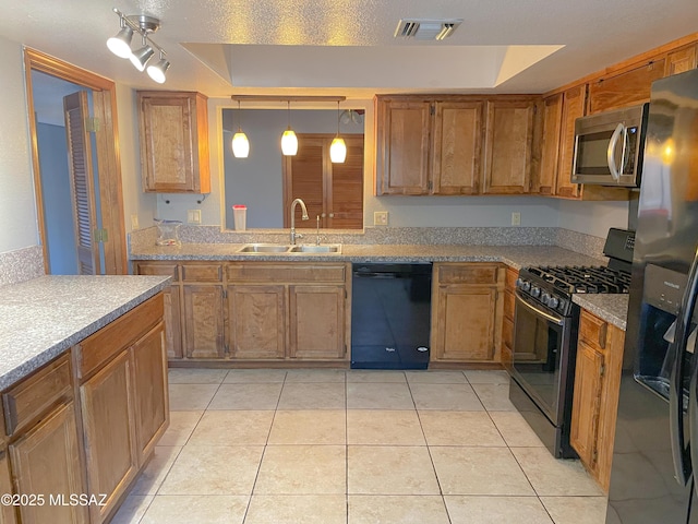 kitchen featuring hanging light fixtures, a tray ceiling, sink, and black appliances