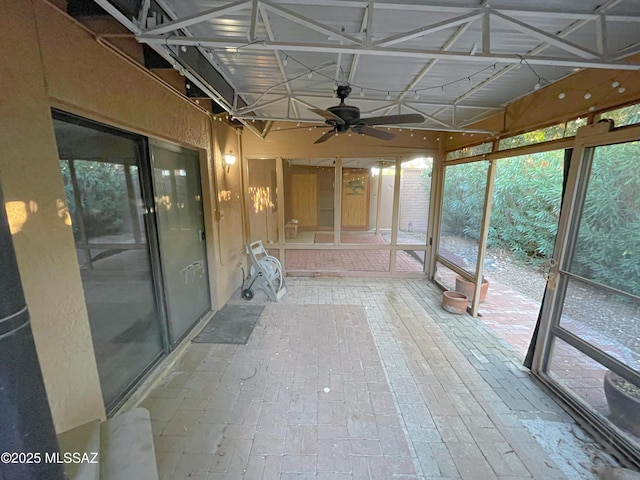 unfurnished sunroom featuring ceiling fan