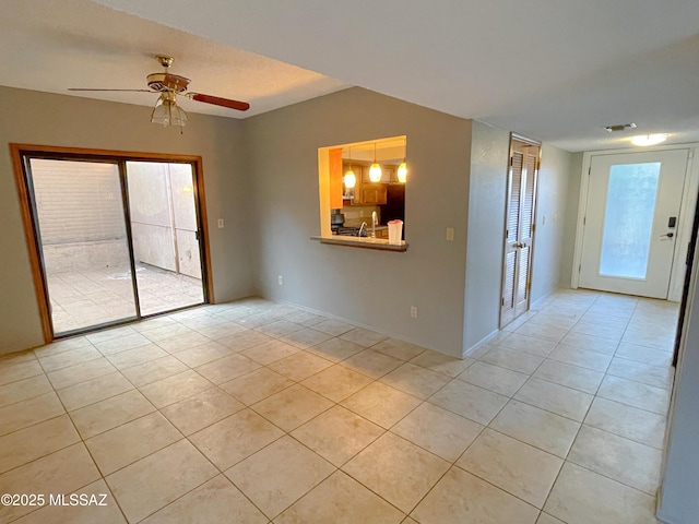 spare room featuring light tile patterned flooring, ceiling fan, a healthy amount of sunlight, and sink