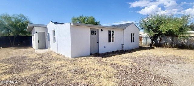 view of front of house with fence and stucco siding